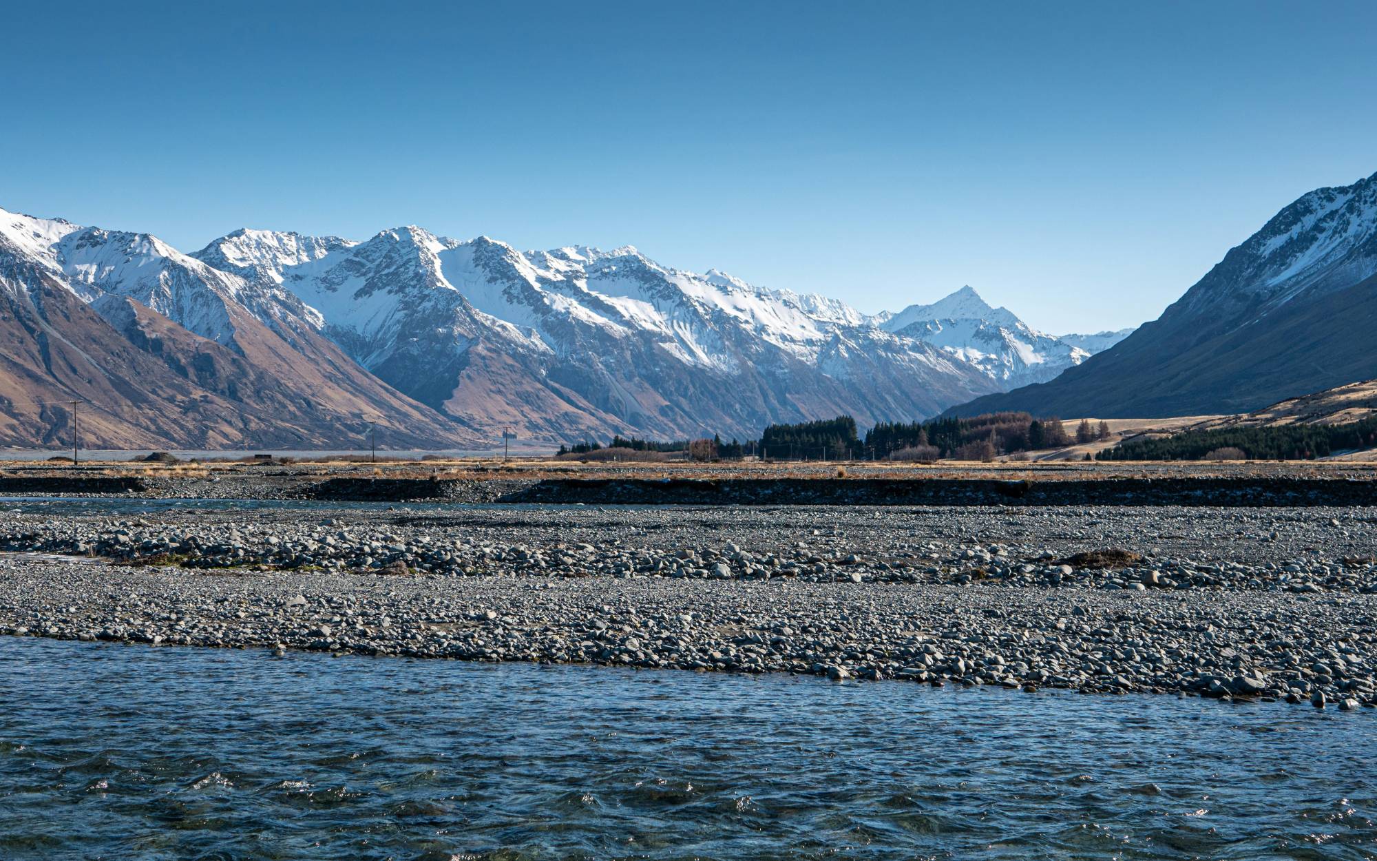 Braided river crossing below snow-capped mountains in the New Zealand high country